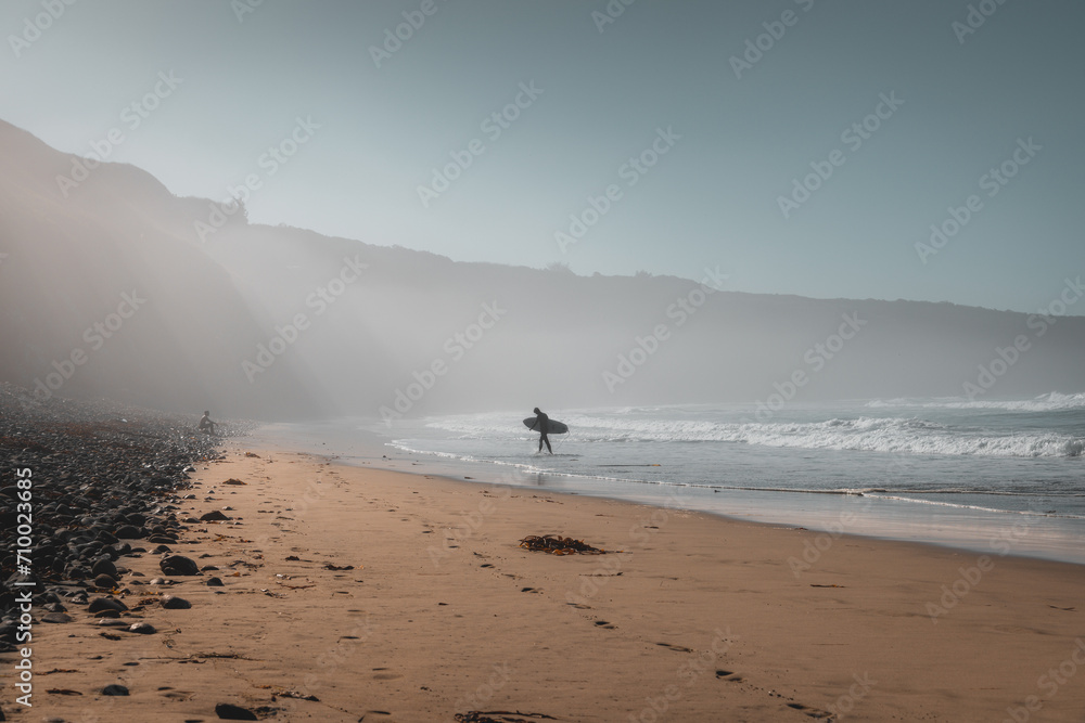 Surfer on Beach with Light Beams