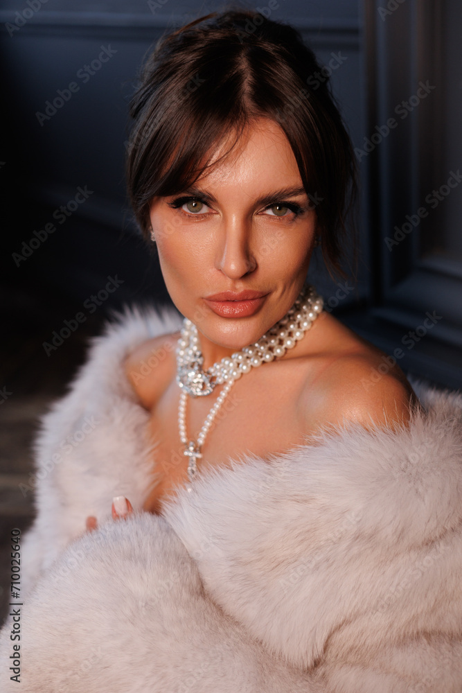 Beautiful woman in red evening dress and fur coat near Christmas Tree. Posch middle-aged lady with gorgeous jewelry in fur coat. Portrait of girl in black room celebrate New Year. Beautiful woman in red evening dress and fur coat near Christmas Tree. Posch middle-aged lady with gorgeous jewelry in fur coat. Portrait of girl in black room celebrate New Year.