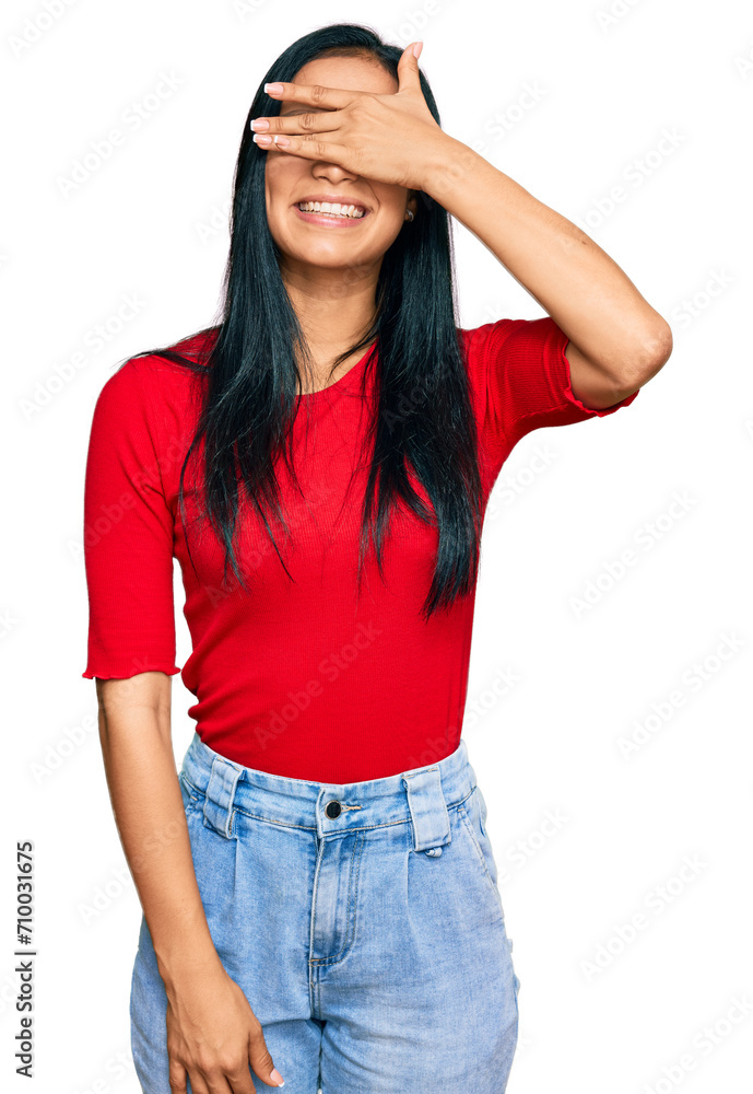 Beautiful hispanic woman wearing casual clothes smiling and laughing with hand on face covering eyes for surprise. blind concept. Beautiful hispanic woman wearing casual clothes smiling and laughing with hand on face covering eyes for surprise. blind concept.