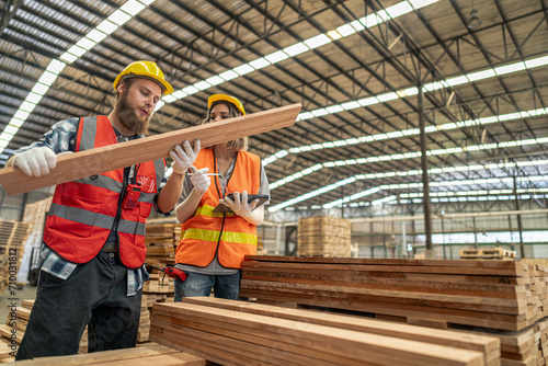 workers man and woman engineering walking and inspecting timbers wood in warehouse. Concept of smart industry worker operating. Wood factories produce wood palate.