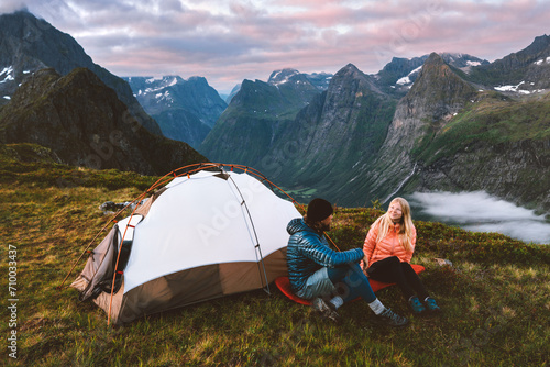 Couple man and woman traveling together with camping tent gear romantic vacations friends hiking adventure outdoor family healthy lifestyle climbing mountains of Norway Valentines day holiday