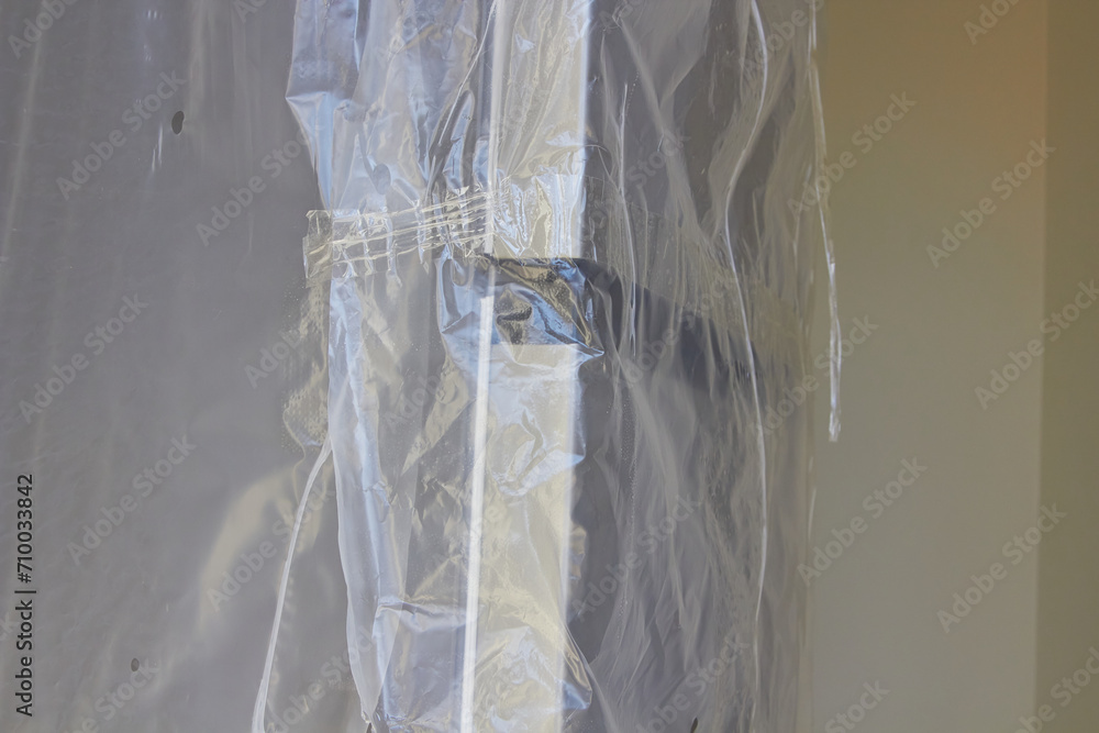 new refrigerator in polyethylene film, packaging of the refrigerator in a film, protection from