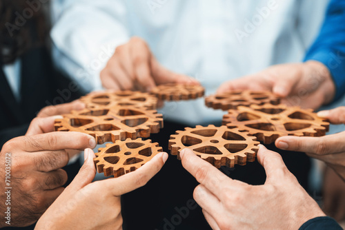 Business team joining cogwheel in circular together symbolize successful group of business partnership and strong collective unity teamwork in community workplace with productive efficiency. Prudent photo
