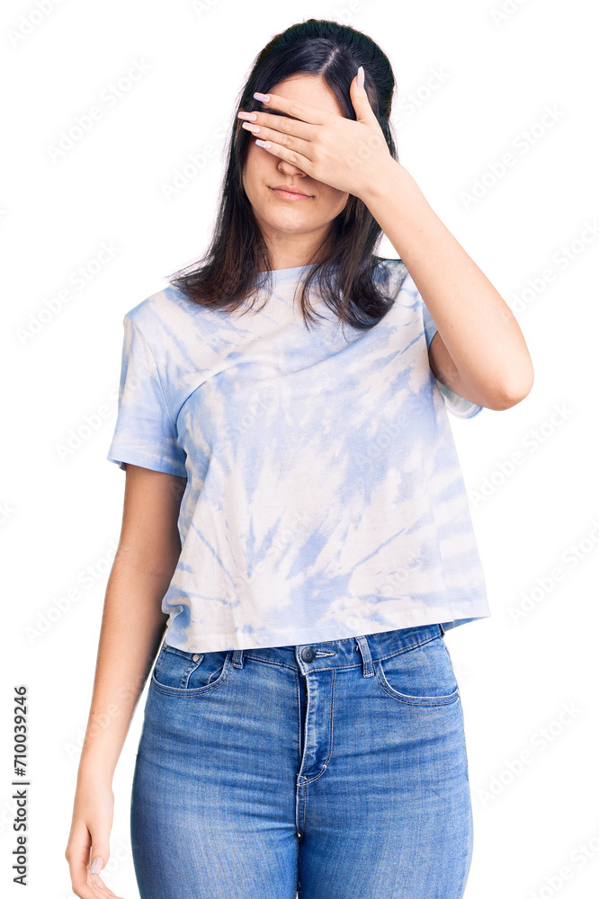 Young beautiful girl wearing casual t shirt covering eyes with hand, looking serious and sad. sightless, hiding and rejection concept Young beautiful girl wearing casual t shirt covering eyes with hand, looking serious and sad. sightless, hiding and rejection concept
