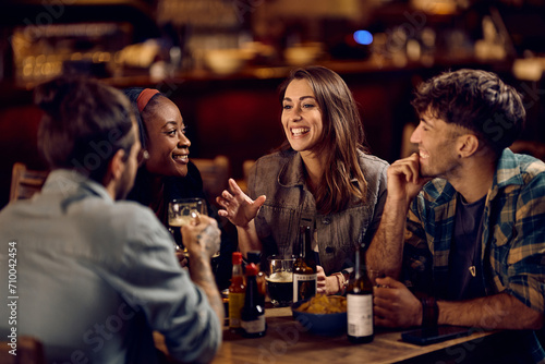 Happy woman talking to her friends while gathering in pub.