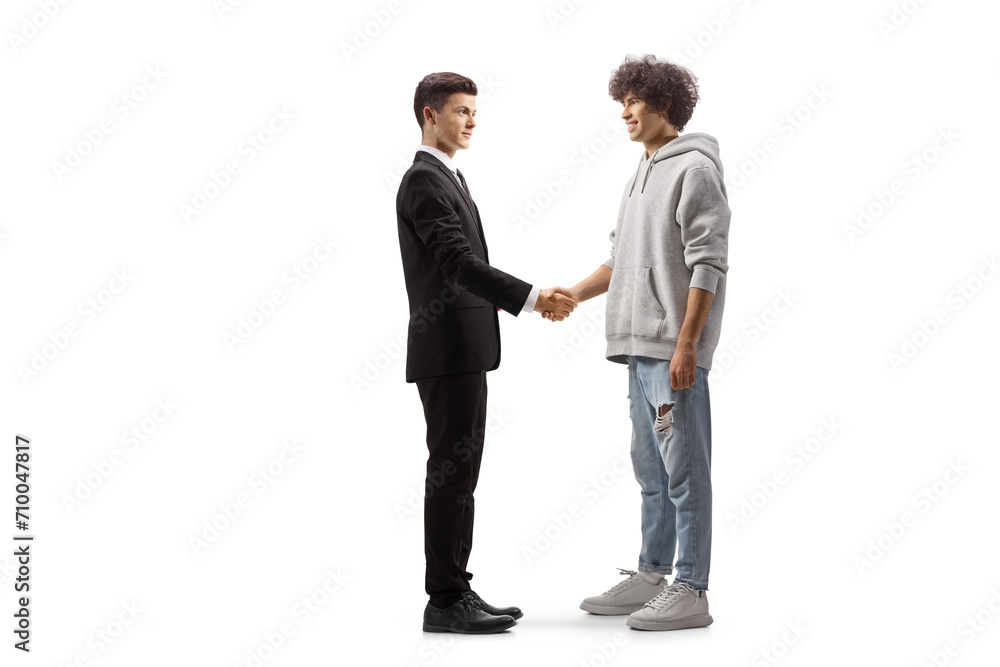 Full length profile shot of a young casual man shaking hands with a young professional man Full length profile shot of a young casual man shaking hands with a young professional man