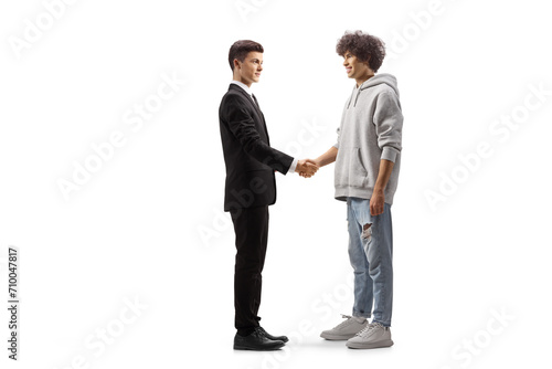 Full length profile shot of a young casual man shaking hands with a young professional man