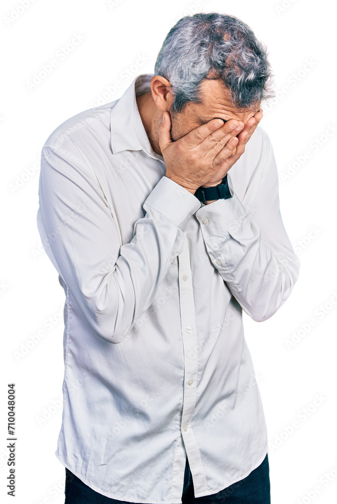 Middle age hispanic with grey hair wearing casual white shirt with sad expression covering face with hands while crying. depression concept. Middle age hispanic with grey hair wearing casual white shirt with sad expression covering face with hands while crying. depression concept.