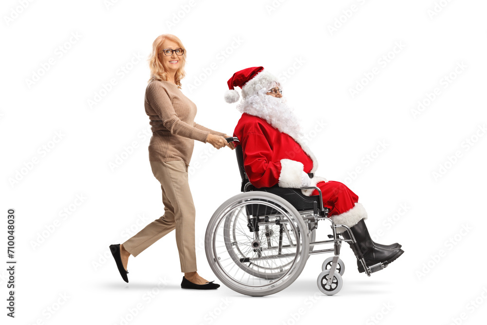 Middle aged woman pushing Santa claus in a wheelchair Middle aged woman pushing Santa claus in a wheelchair