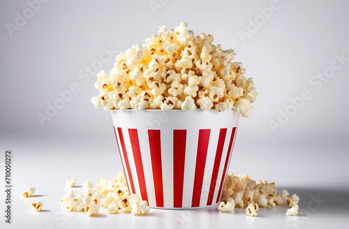 popcorn in a white bucket with red stripes on a white background