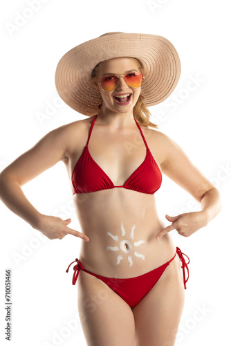 Beautiful smiling blond woman in red bikini with cosmetic product in sun shape on her belly on white background.
