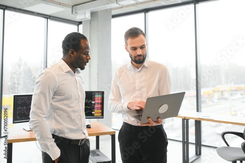 Two diverse crypto traders brokers stock exchange market investors discussing trading charts research reports growth using pc computer looking at screen analyzing invest strategy, financial risks