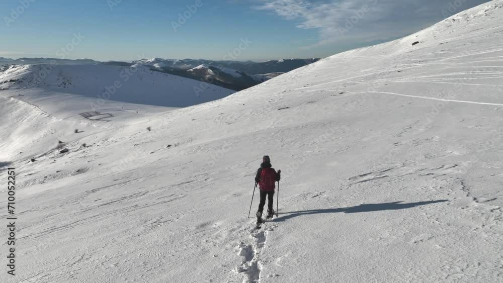 Mountaineer descending a snowy slope with snowshoes Mountaineer descending a snowy slope with snowshoes