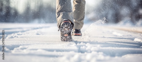 A well-captured image of a person wearing snowboots walking in the snow. photo