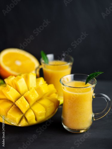 Orange and mango smoothies   two glasses on a black table
