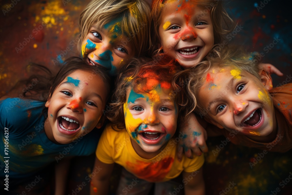 Obraz premium A little boy and girl with paint all over his face. Beautiful girl and boy play with colored smoke. They look at the camera. Summer games.