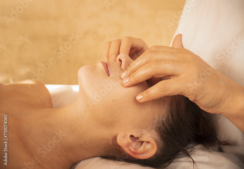 masseur does facial massage, spa procedures, cosmetology facials, face-building massage