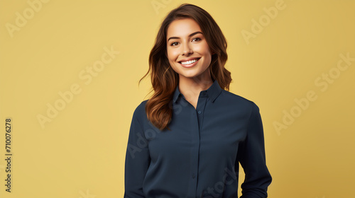 A woman with a warm smile is featured against a soft yellow background, wearing a smart navy blue blouse. The image suitable for corporate or casual business representation.