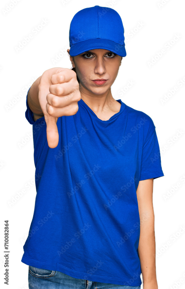 Young hispanic girl wearing delivery courier uniform looking unhappy and angry showing rejection and negative with thumbs down gesture. bad expression.