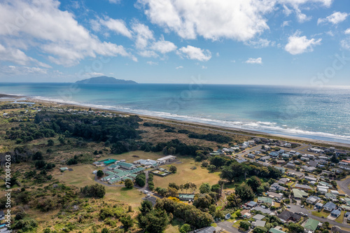 An aerial shot looking south from Otaki over the flat plains and in the distance Kapiti Island. The disused health camp is seen in the foreground