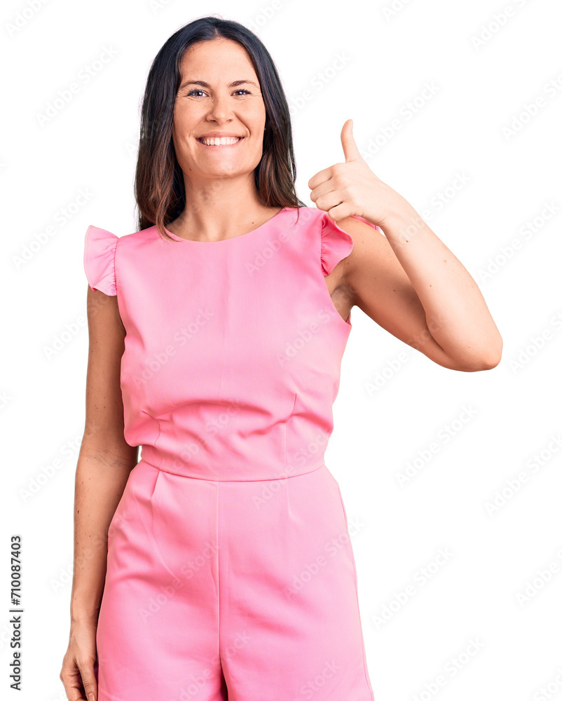Young beautiful brunette woman wearing casual dress smiling happy and positive, thumb up doing excellent and approval sign Young beautiful brunette woman wearing casual dress smiling happy and positive, thumb up doing excellent and approval sign