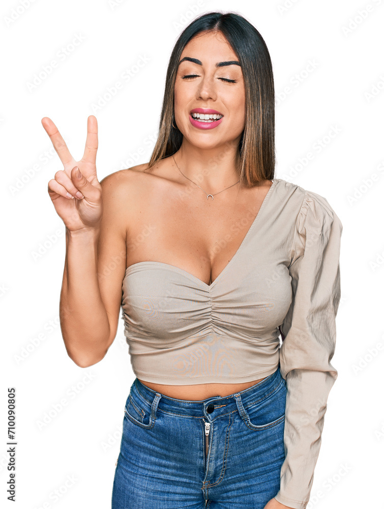 Young hispanic woman wearing casual clothes showing and pointing up with fingers number two while smiling confident and happy. Young hispanic woman wearing casual clothes showing and pointing up with fingers number two while smiling confident and happy.