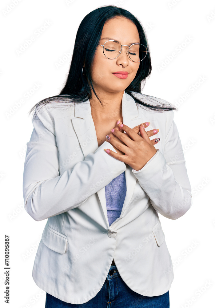 Beautiful hispanic woman with nose piercing wearing business jacket and glasses smiling with hands on chest with closed eyes and grateful gesture on face. health concept. Beautiful hispanic woman with nose piercing wearing business jacket and glasses smiling with hands on chest with closed eyes and grateful gesture on face. health concept.