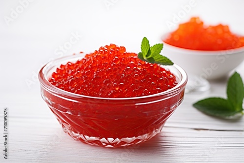 Fresh red caviar in bowl on wooden background
