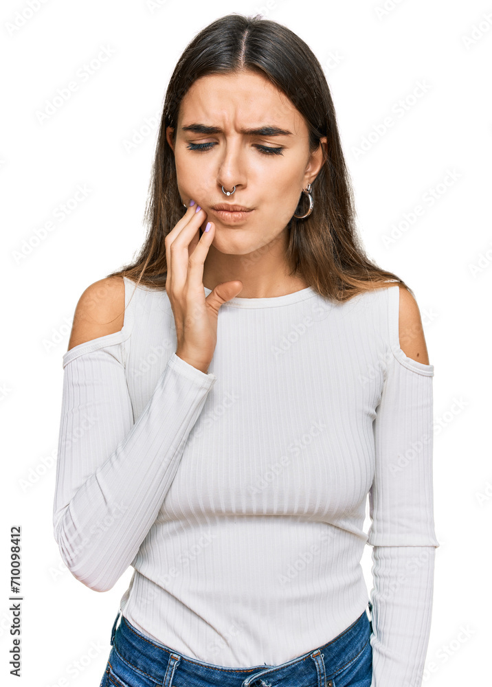 Young hispanic woman wearing casual clothes touching mouth with hand with painful expression because of toothache or dental illness on teeth. dentist Young hispanic woman wearing casual clothes touching mouth with hand with painful expression because of toothache or dental illness on teeth. dentist