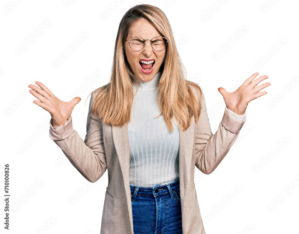 Young blonde woman wearing business shirt and glasses celebrating mad and crazy for success with arms raised and closed eyes screaming excited. winner concept Young blonde woman wearing business shirt and glasses celebrating mad and crazy for success with arms raised and closed eyes screaming excited. winner concept