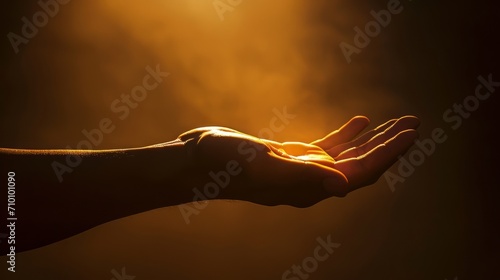 A conceptual photograph of a hand reaching out from the darkness towards a glowing light, symbolizing hope and uncertainty. The minimalistic composition and contrast of warm and cool tones. 