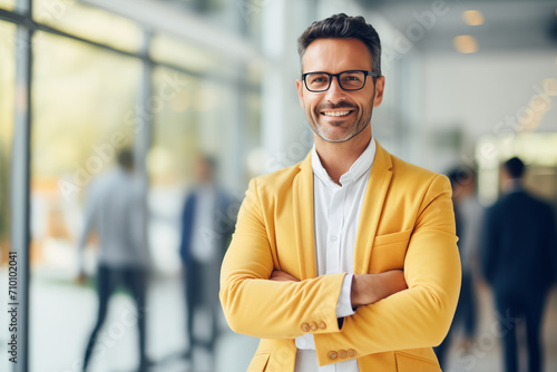 happy businessman ceo, man, standing in office arms crossed, in yellow jacket, in glasses, slight unshaven