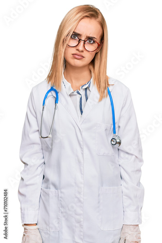 Beautiful caucasian woman wearing doctor uniform and stethoscope skeptic and nervous, frowning upset because of problem. negative person.
