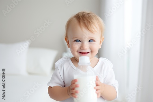 Little baby boy drinks milk from a bottle © Alina