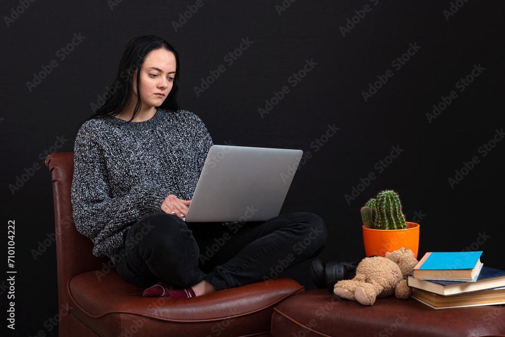 focused young freelance woman sitting with laptop and headphones, working remotely online from home focused young freelance woman sitting with laptop and headphones, working remotely online from home
