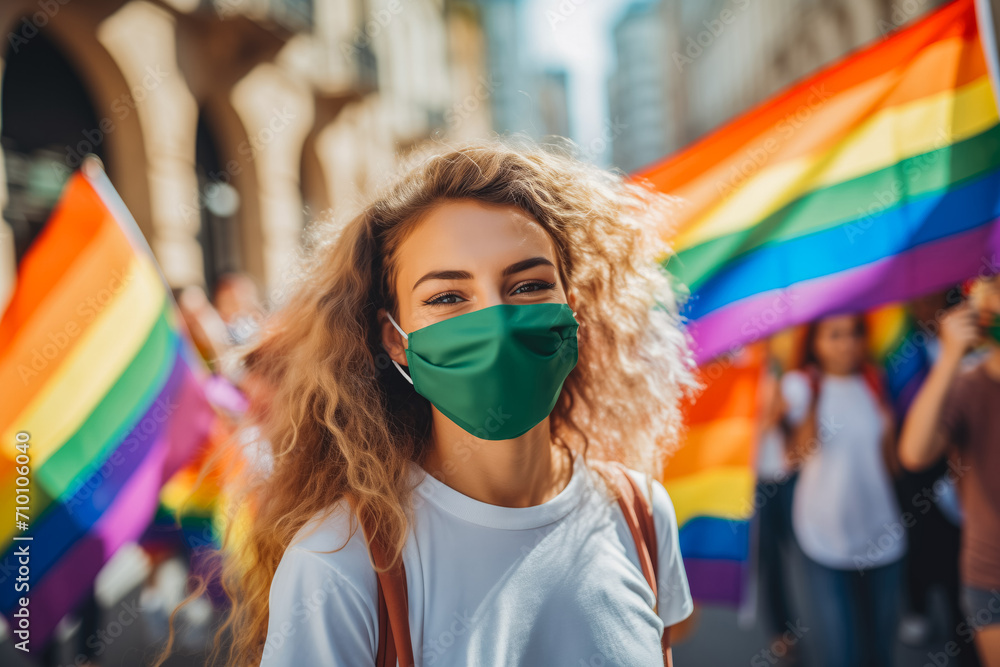 Gay people smiling at pride parade with LGBT flags while wearing protective face mask - Main focus on left girl face.
