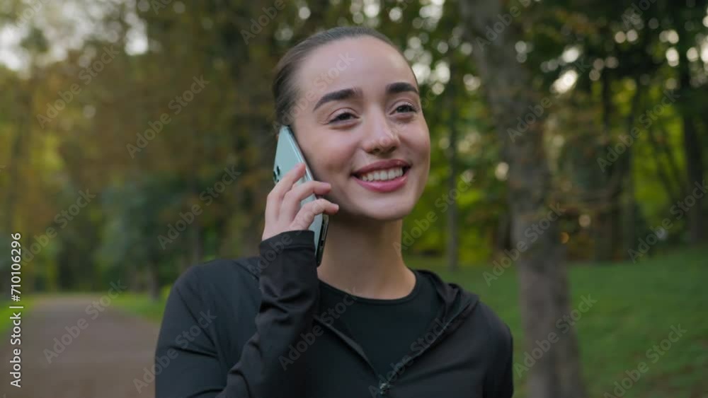 Caucasian active young woman sport girl speaking mobile phone happy joyful female sportswoman talking smartphone communicating in city park walking with sports bottle water relax after workout morning Caucasian active young woman sport girl speaking mobile phone happy joyful female sportswoman talking smartphone communicating in city park walking with sports bottle water relax after workout morning