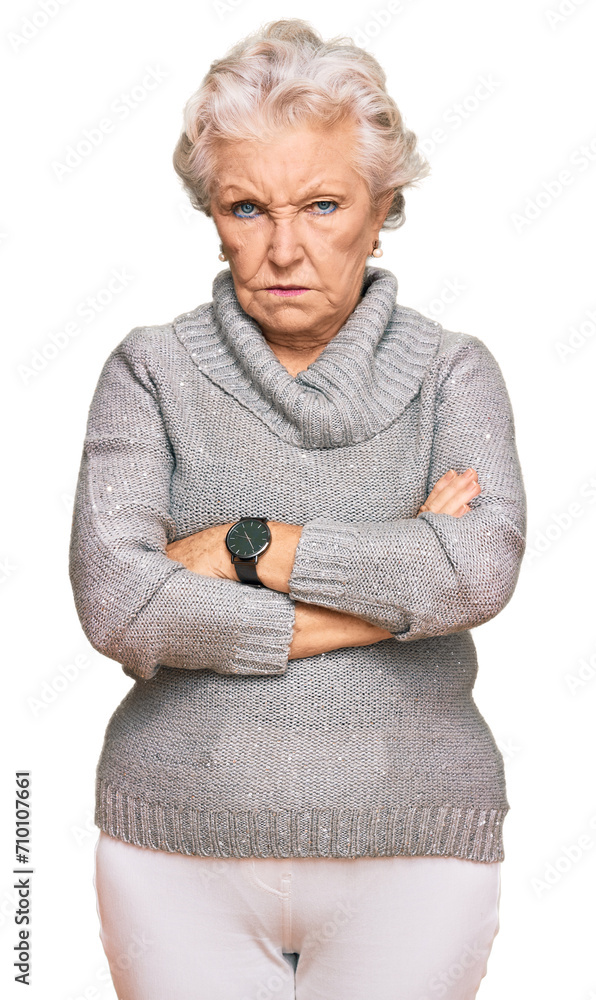Senior grey-haired woman wearing casual winter sweater skeptic and nervous, disapproving expression on face with crossed arms. negative person. Senior grey-haired woman wearing casual winter sweater skeptic and nervous, disapproving expression on face with crossed arms. negative person.