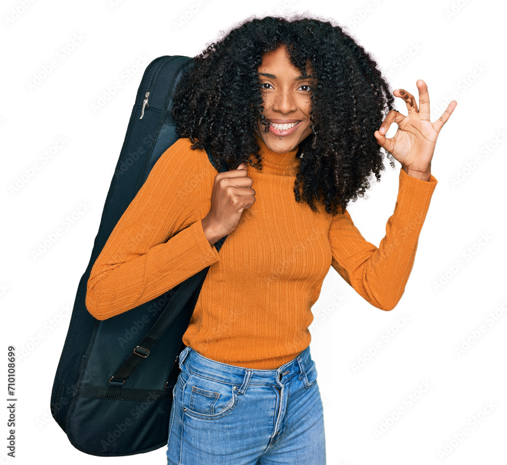 Young african american girl wearing guitar case doing ok sign with fingers, smiling friendly gesturing excellent symbol Young african american girl wearing guitar case doing ok sign with fingers, smiling friendly gesturing excellent symbol