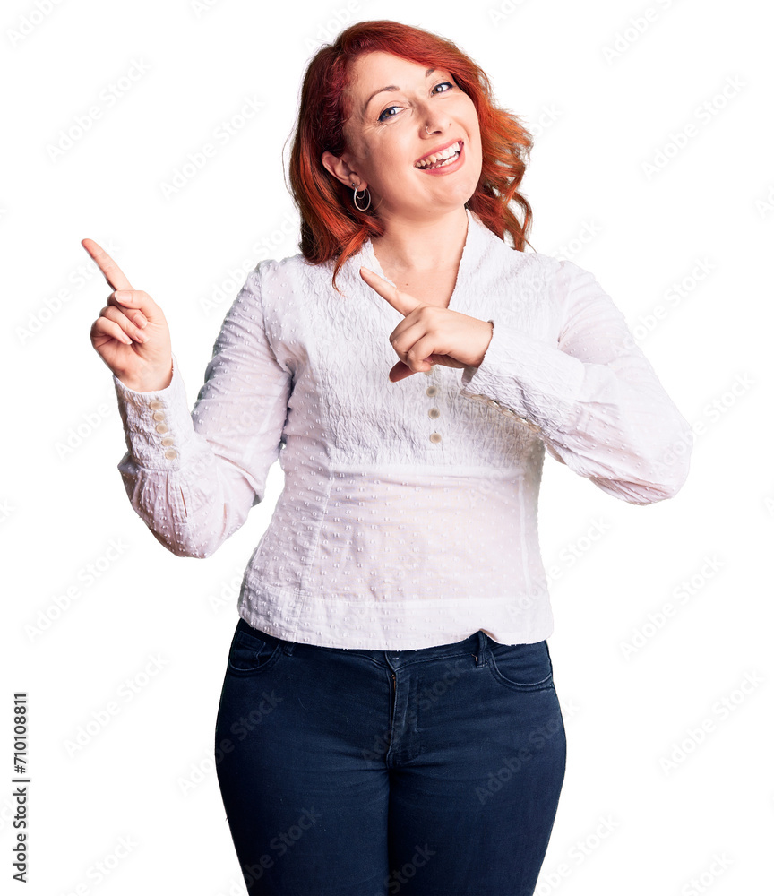 Young beautiful redhead woman wearing casual shirt smiling and looking at the camera pointing with two hands and fingers to the side. Young beautiful redhead woman wearing casual shirt smiling and looking at the camera pointing with two hands and fingers to the side.
