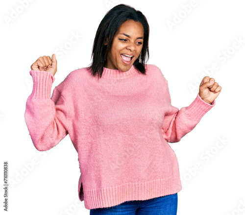 Beautiful hispanic woman wearing casual winter sweater dancing happy and cheerful, smiling moving casual and confident listening to music