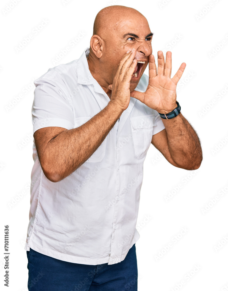 Mature middle east man with mustache wearing casual white shirt shouting angry out loud with hands over mouth Mature middle east man with mustache wearing casual white shirt shouting angry out loud with hands over mouth