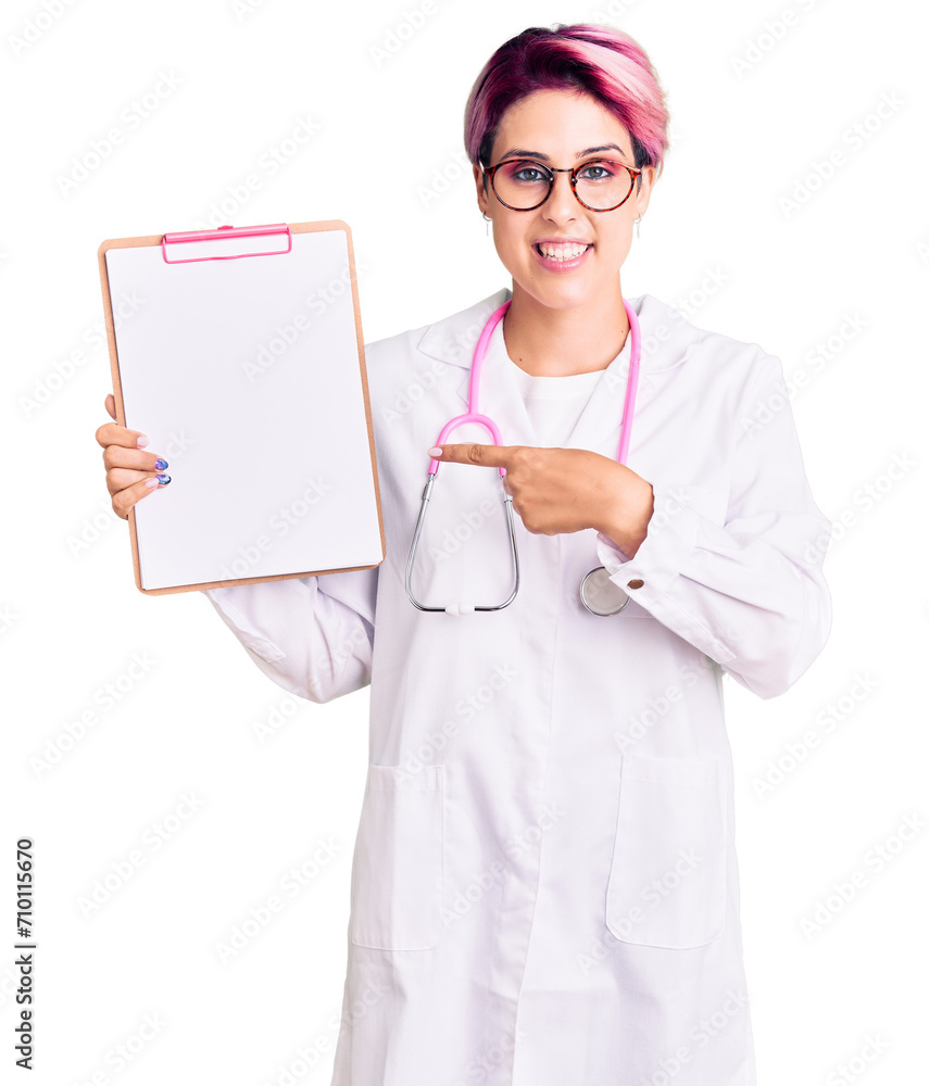 Young beautiful woman with pink hair wearing doctor stethoscope holding clipboard with medical report smiling happy pointing with hand and finger Young beautiful woman with pink hair wearing doctor stethoscope holding clipboard with medical report smiling happy pointing with hand and finger
