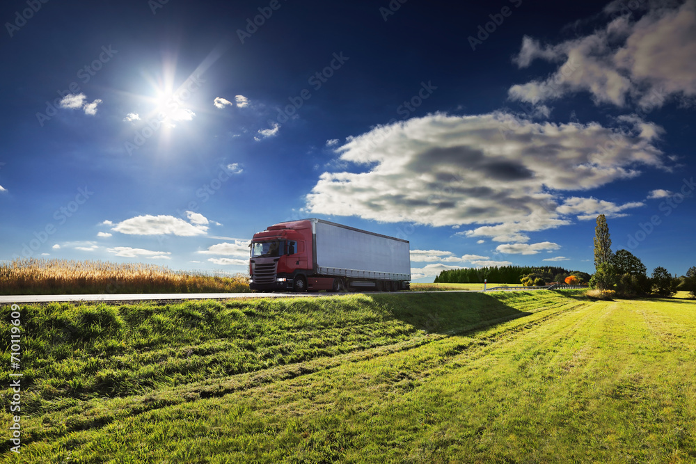 Fototapeta premium Large Transportation Truck on a highway road through the countryside at sunset