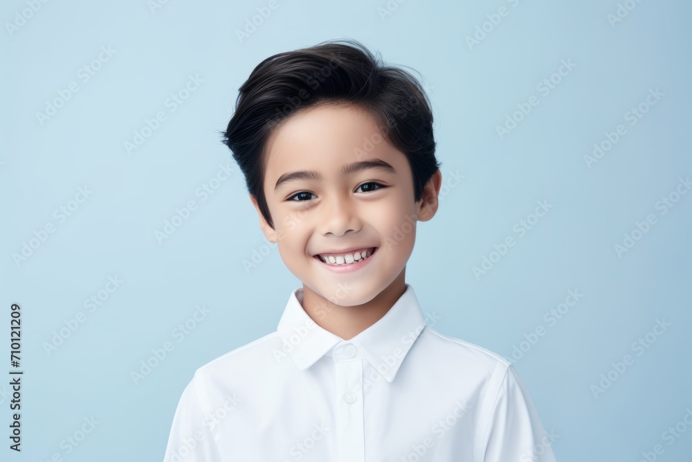 happy asian little boy in white shirt looking at camera over blue background happy asian little boy in white shirt looking at camera over blue background