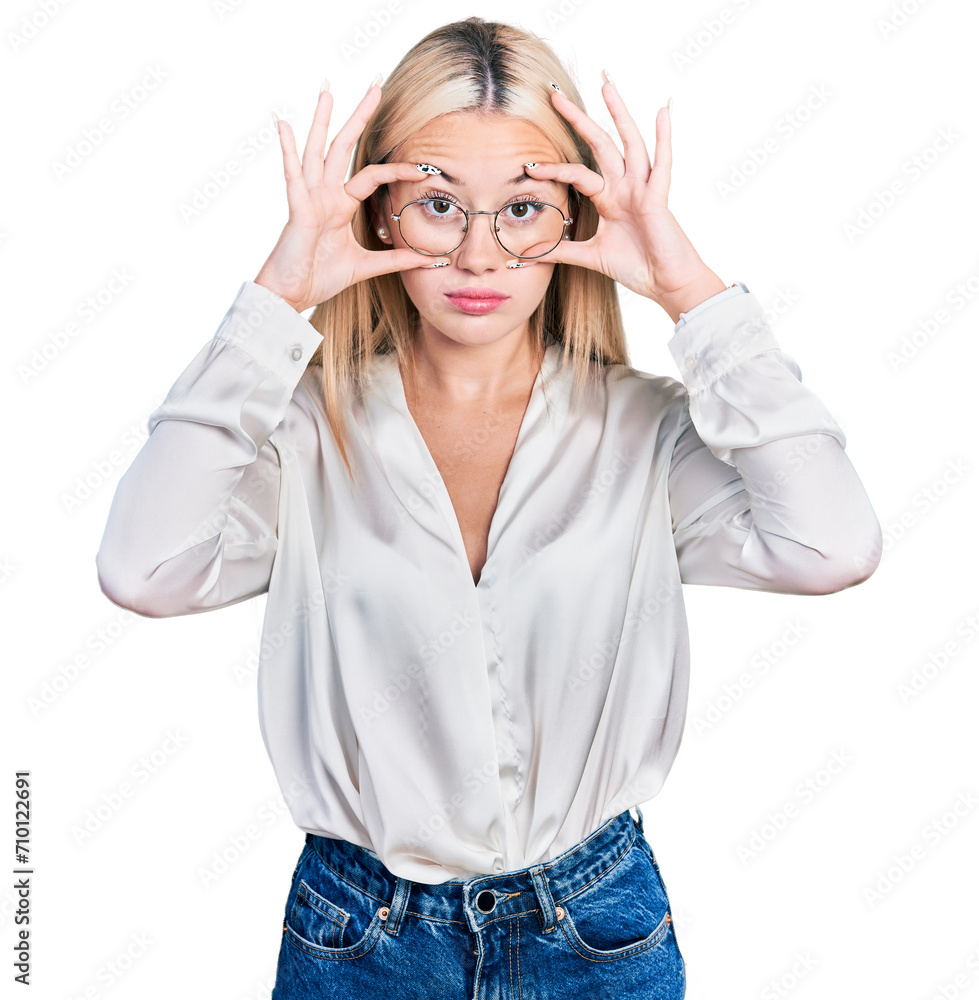 Beautiful blonde woman wearing elegant shirt and glasses trying to open eyes with fingers, sleepy and tired for morning fatigue