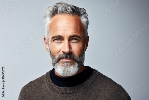 Handsome mature man with grey hair and beard. Studio shot.