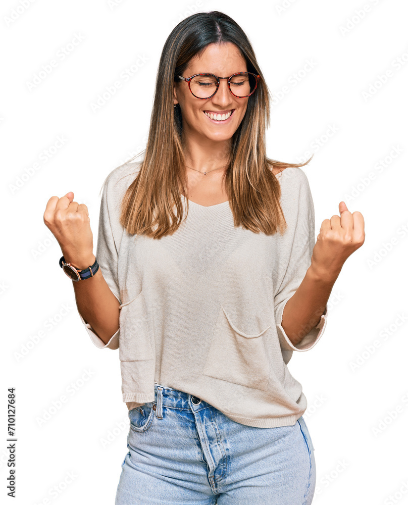 Young woman wearing casual clothes and glasses very happy and excited doing winner gesture with arms raised, smiling and screaming for success. celebration concept. Young woman wearing casual clothes and glasses very happy and excited doing winner gesture with arms raised, smiling and screaming for success. celebration concept.