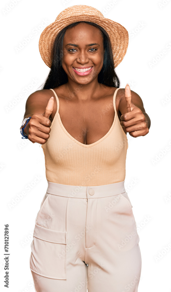 Young black woman wearing summer hat approving doing positive gesture with hand, thumbs up smiling and happy for success. winner gesture. Young black woman wearing summer hat approving doing positive gesture with hand, thumbs up smiling and happy for success. winner gesture.