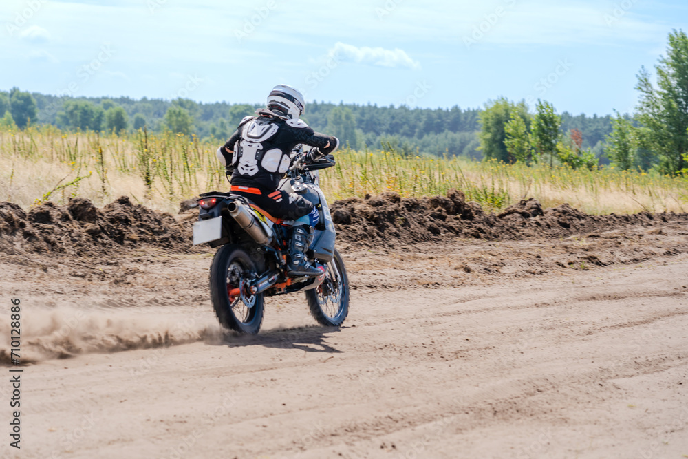 Motocross rider riding on extreme dust track Motocross rider riding on extreme dust track